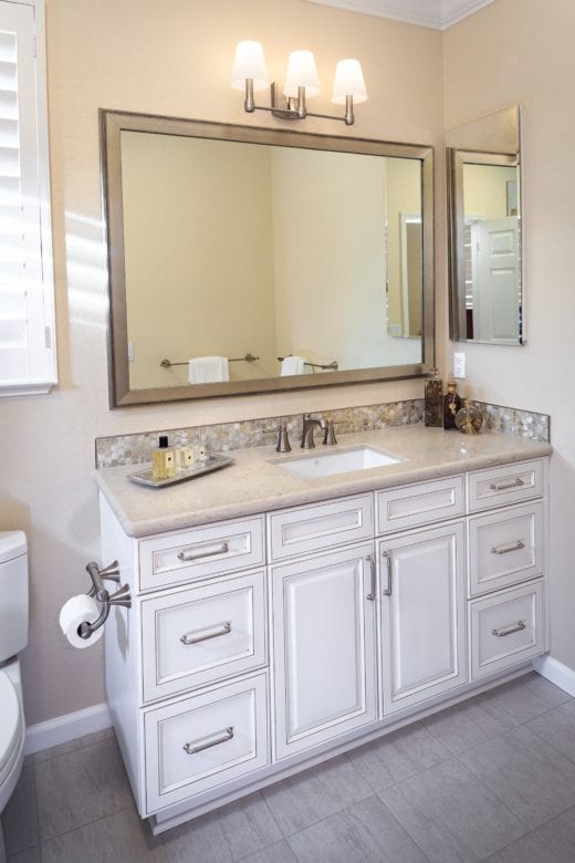 Vanity with tile backsplash, large mirror