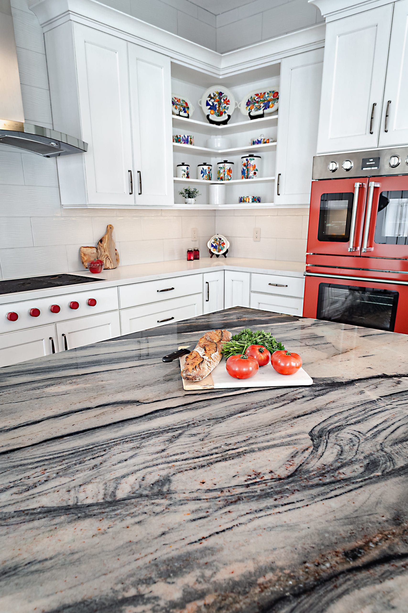 Dramatic quartzite countertops and red wall oven
