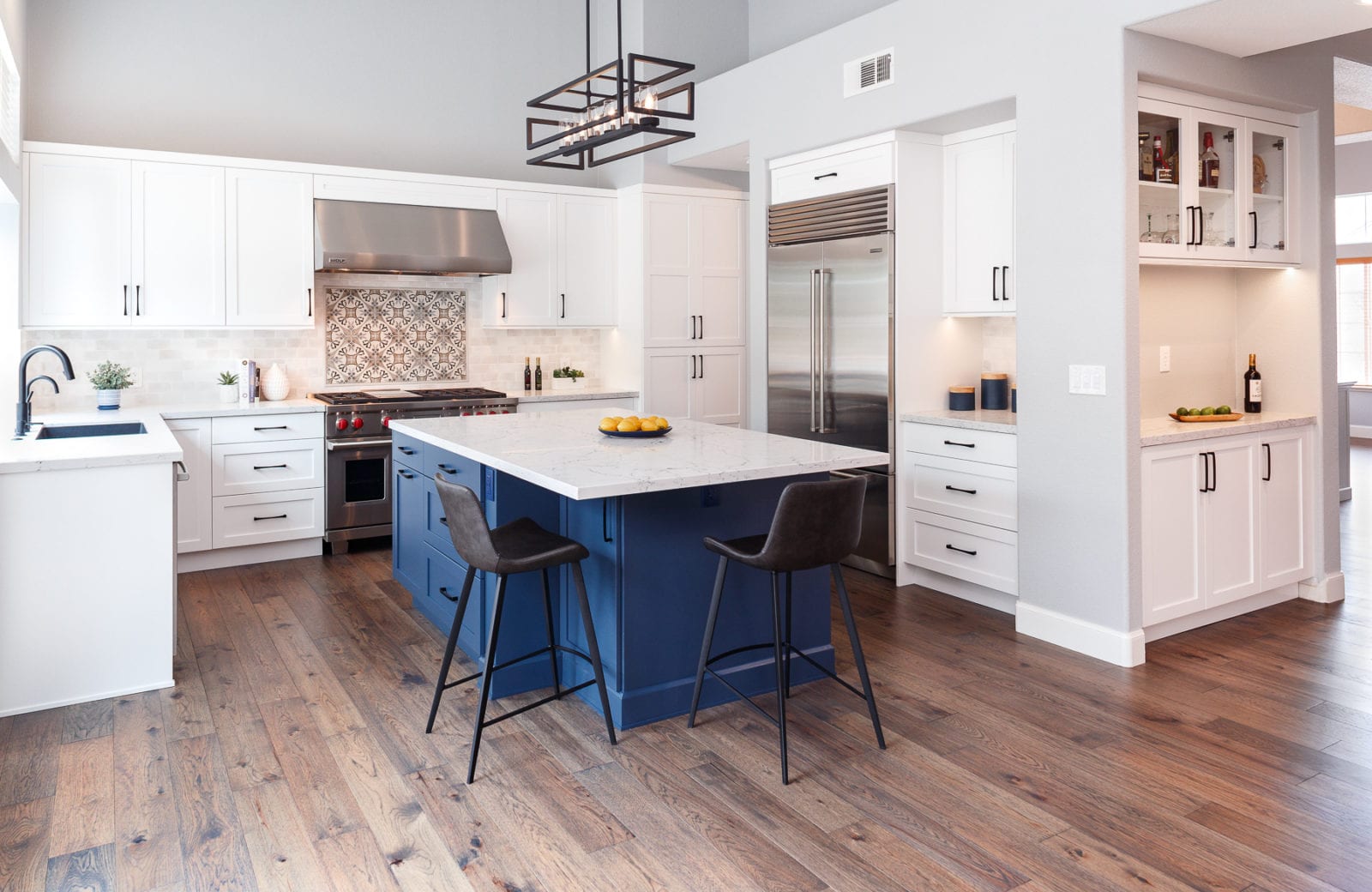open plan kitchen with blue island and hardwood floors