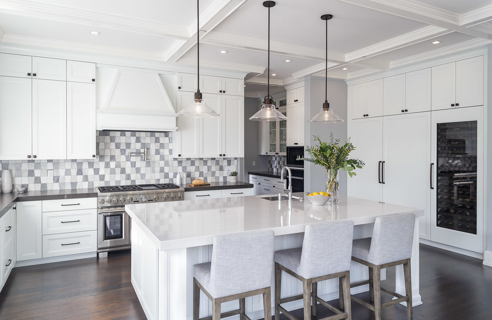 Large open plan kitchen remodel with large island, quartz countertops, white painted cabinets, gray checkered tile backsplash