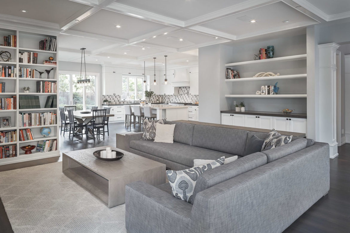 open plan eat in kitchen with large island, family room with open shelving and painted cabinetry