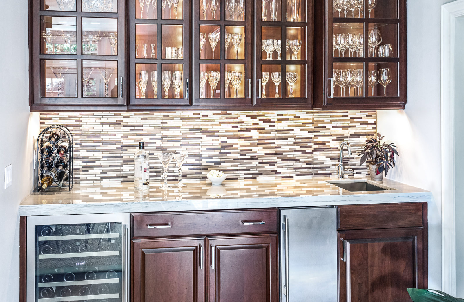 Bar with wood cabinets, bar sink, tile backsplash