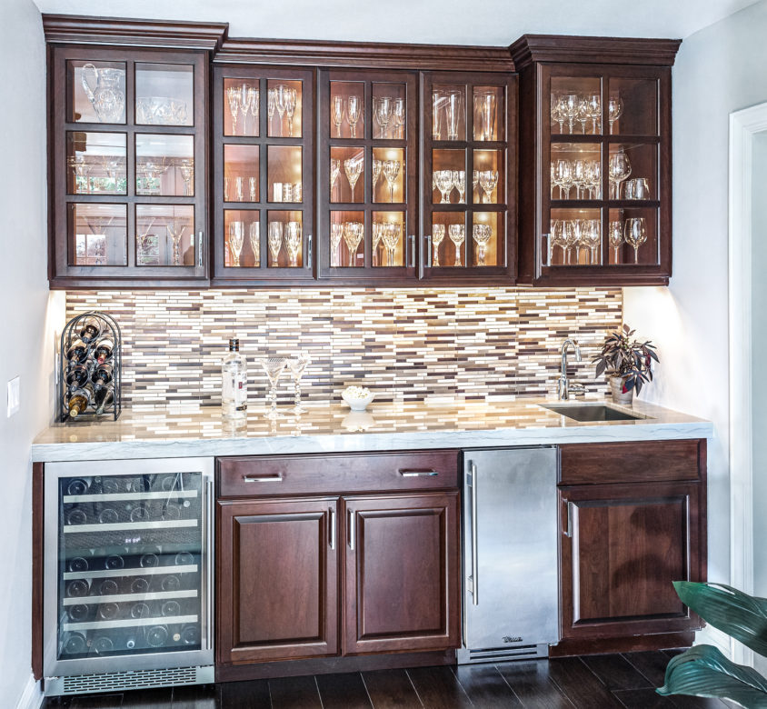 Bar with wood cabinets, bar sink, tile backsplash