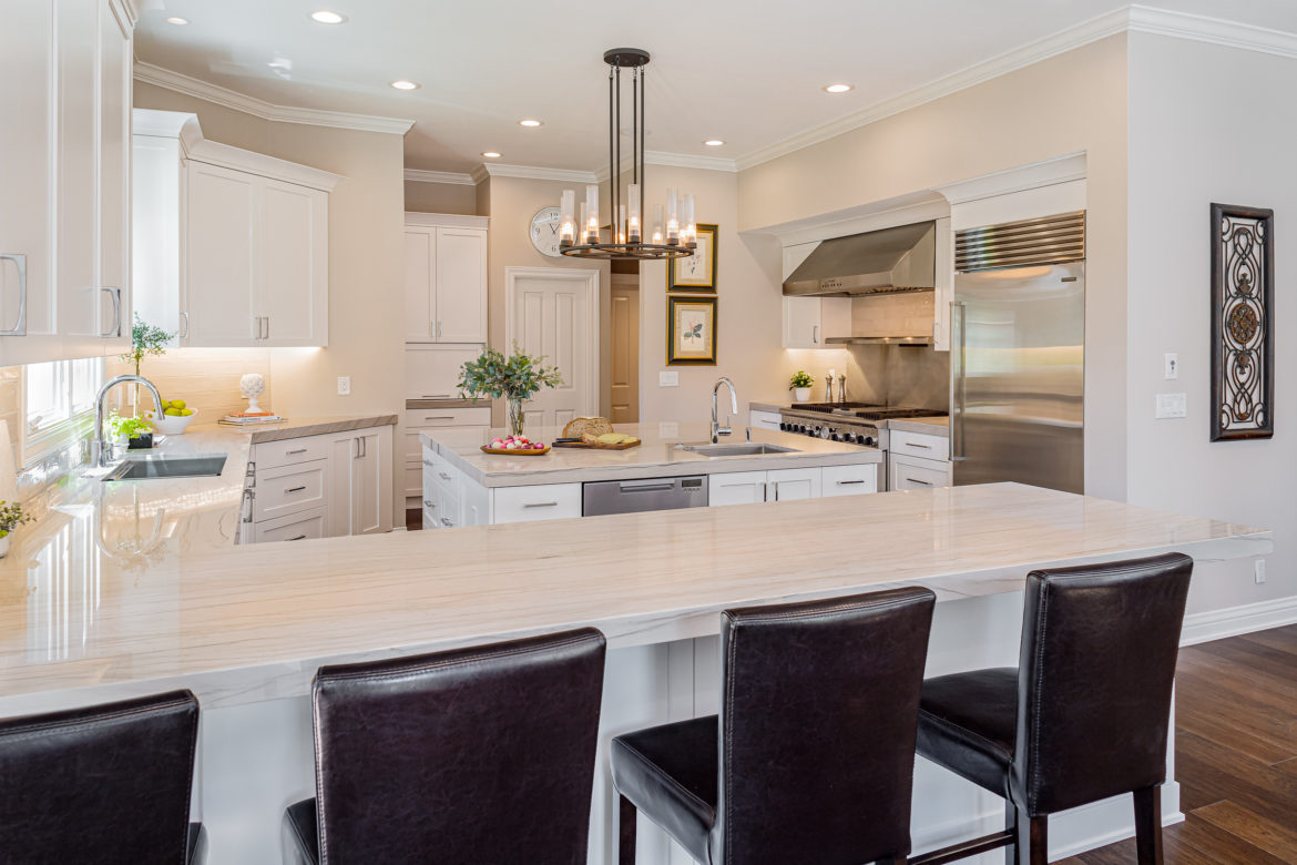 Large U shaped kitchen with island and stainless steel appliances