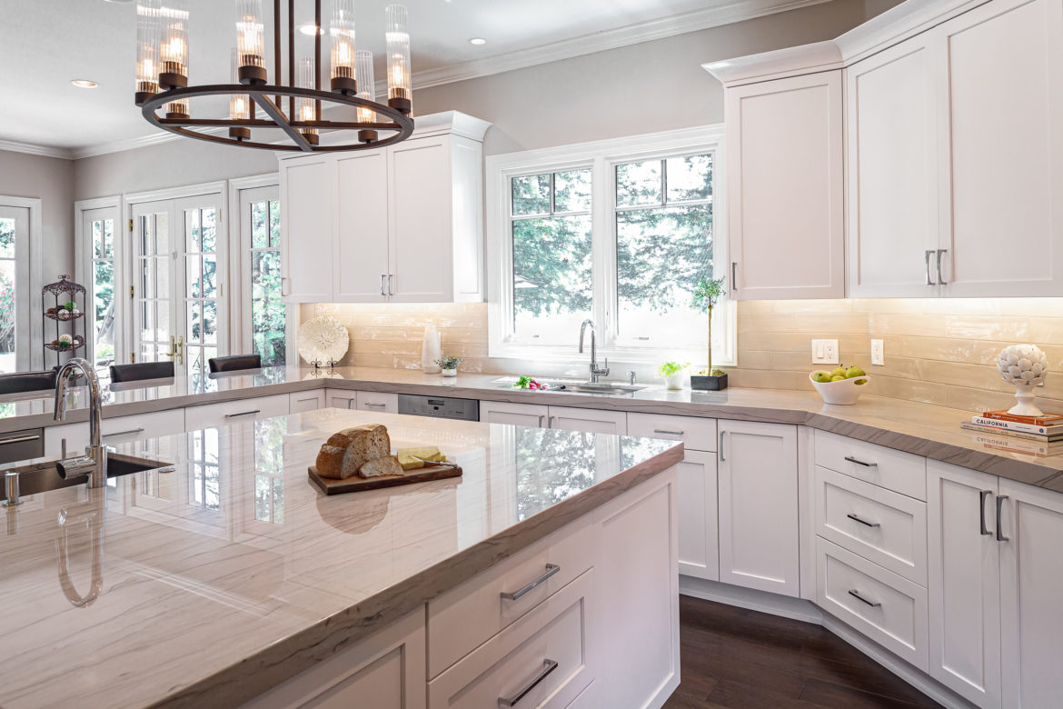 Qartzite countertops and white cabinets on a large island