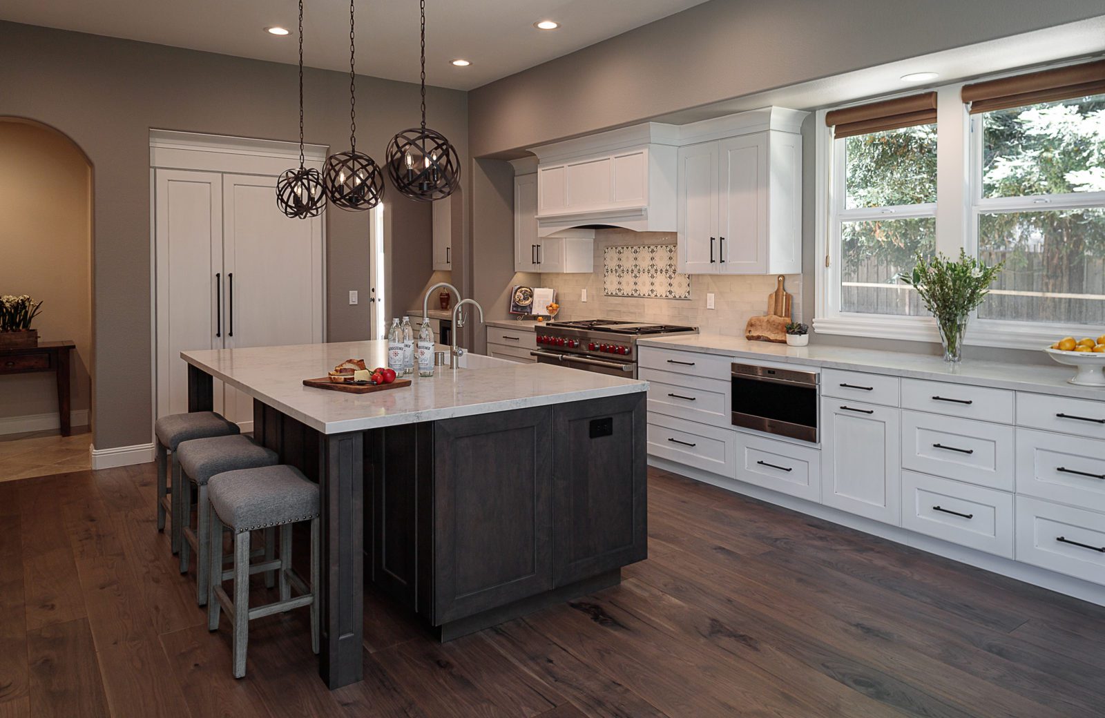 white cabinets, wood floors, large island