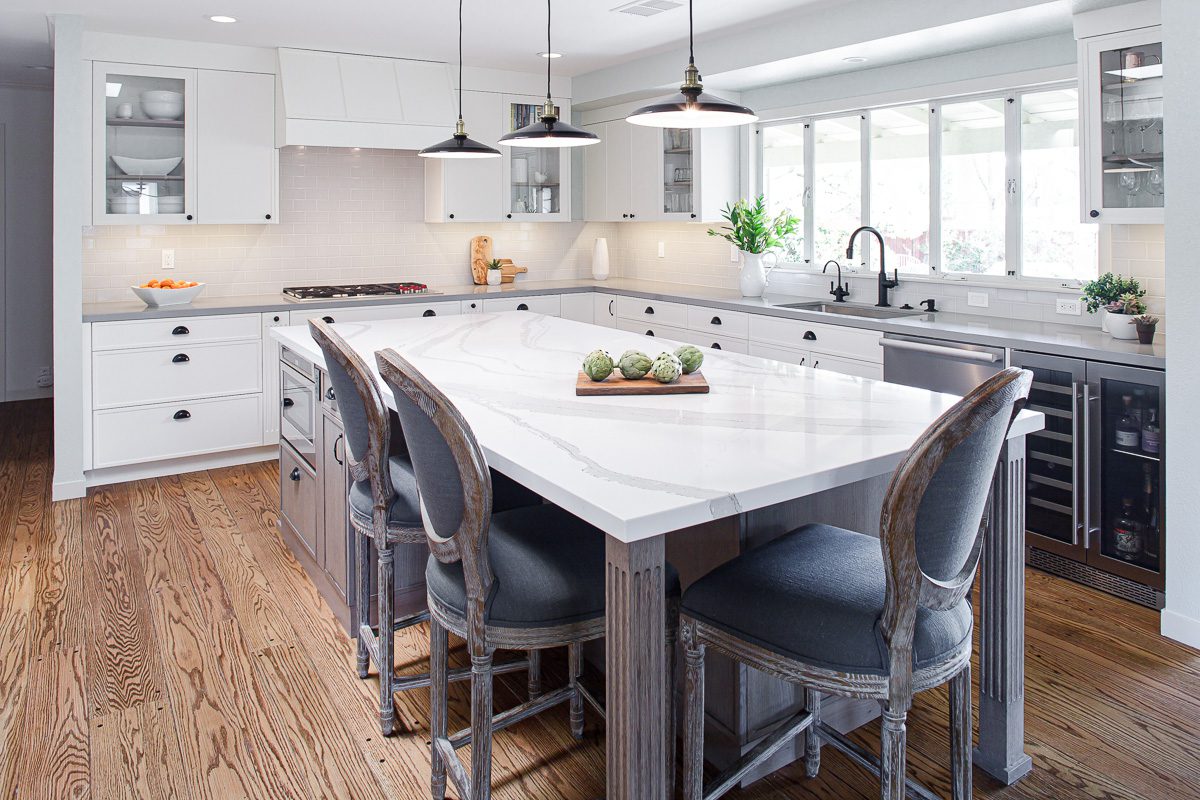 huge white Island white kitchen with full size blue gray chairs