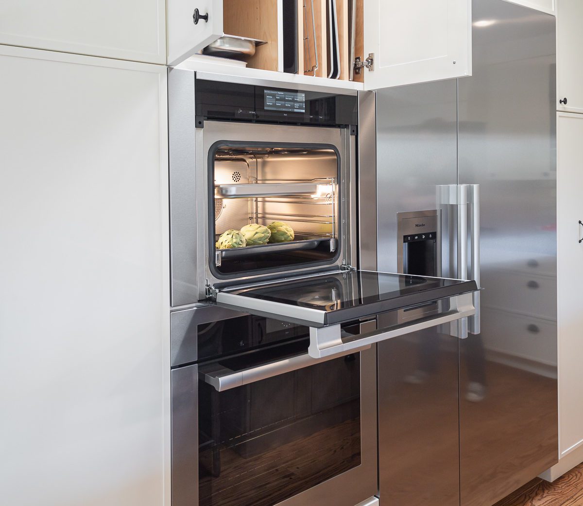 White cabinets Miele refrigerator and modern steam-oven