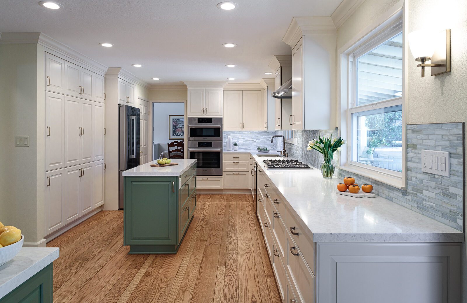 white painted cabinets, green island, wood floors
