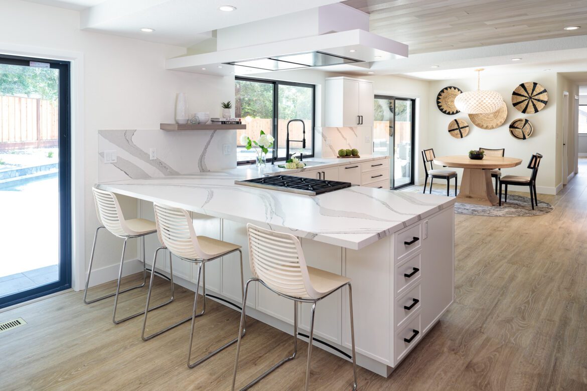 modern kitchen remodel with light LVP floors, white peninsula with space for white seating for 3, wood ceiling panels