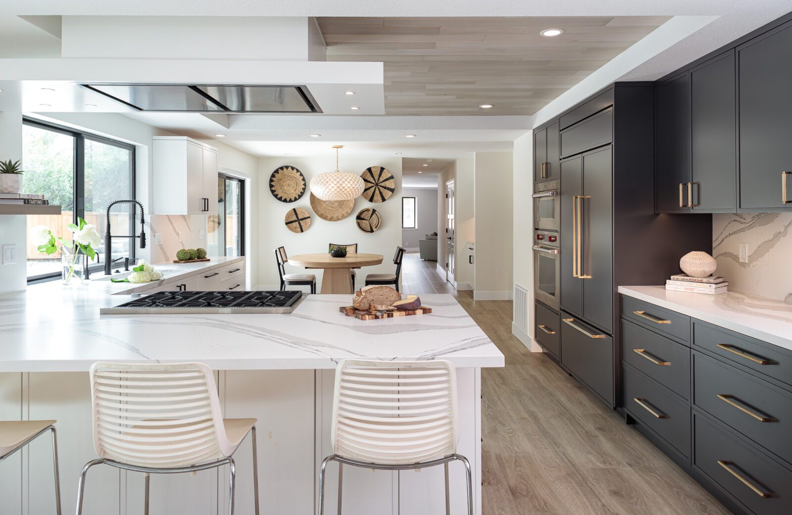 large kitchen with white and black cabinets, wood ceiling, LVP floors