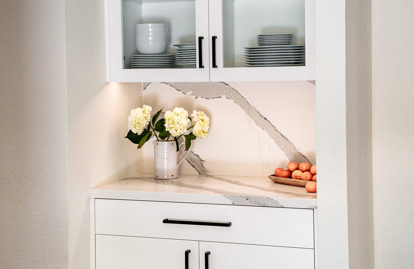 white painted Cystal cabinetry, glass doors, quartz countertops