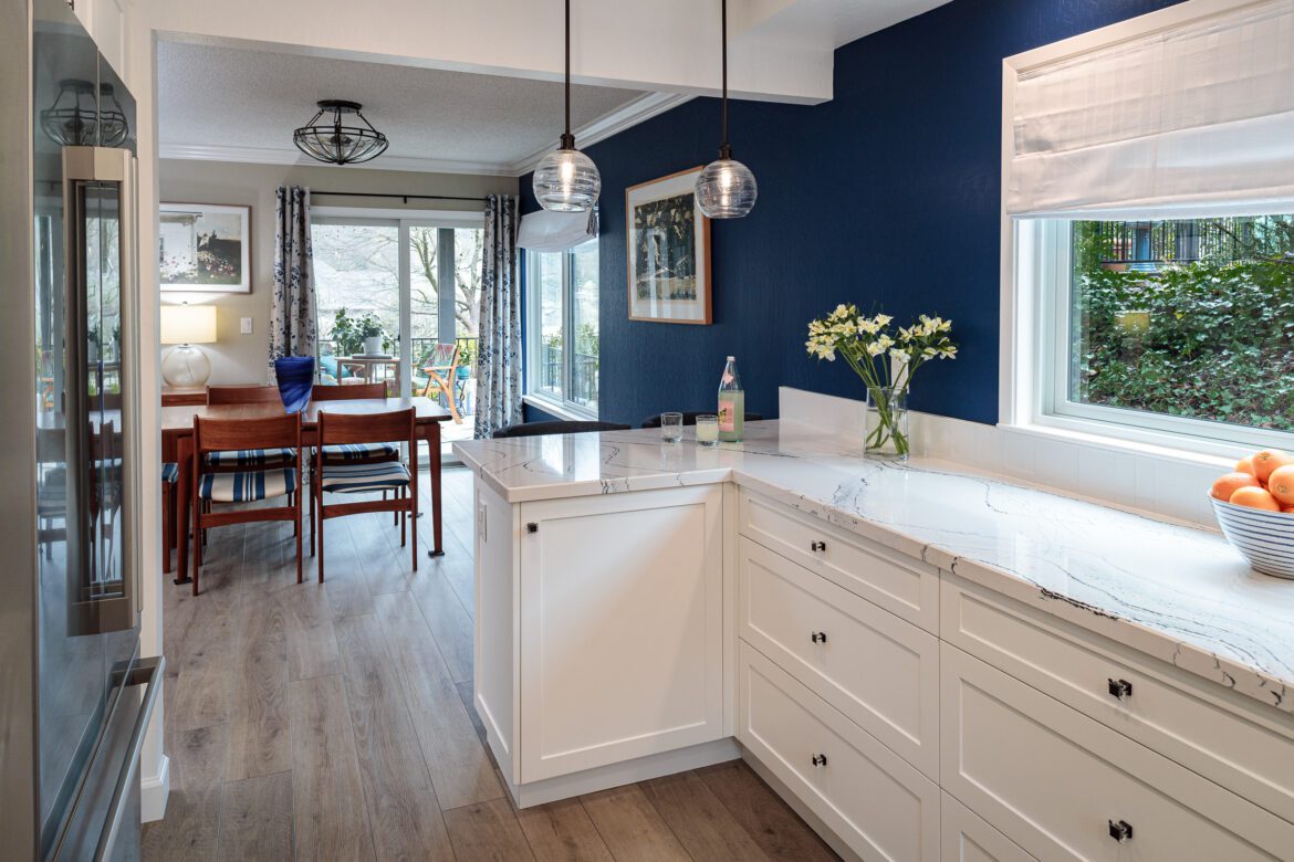 ktichen remodel blue accent wall, and white cabinetry, quartz blue vein countertop, glass pendant lighting