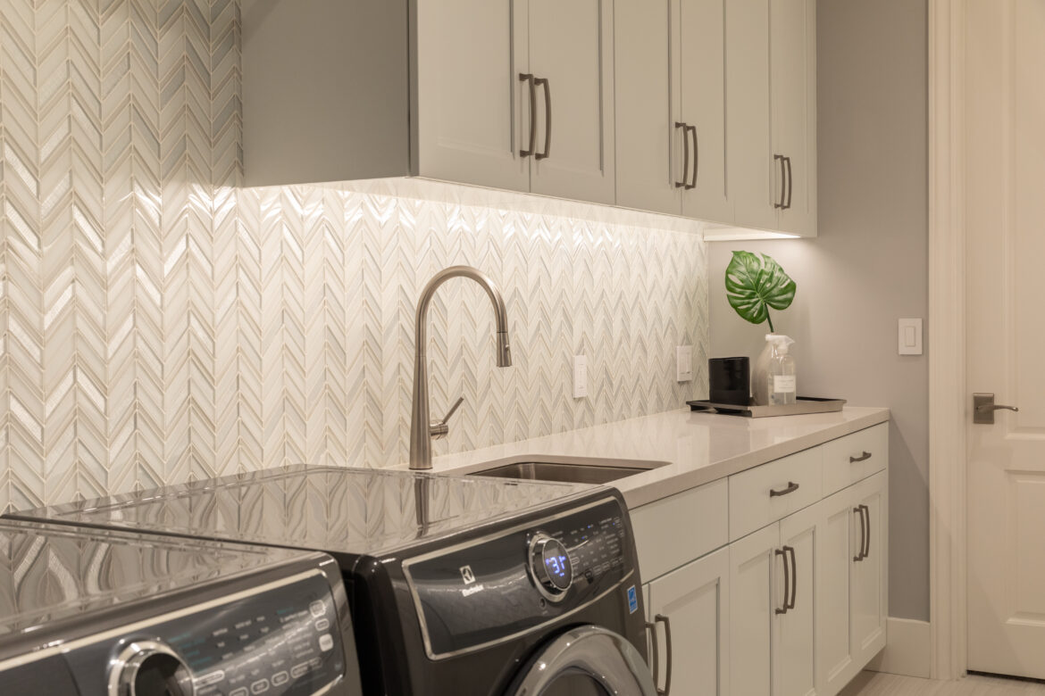 white chevron glass tile wall in laundry room remodel