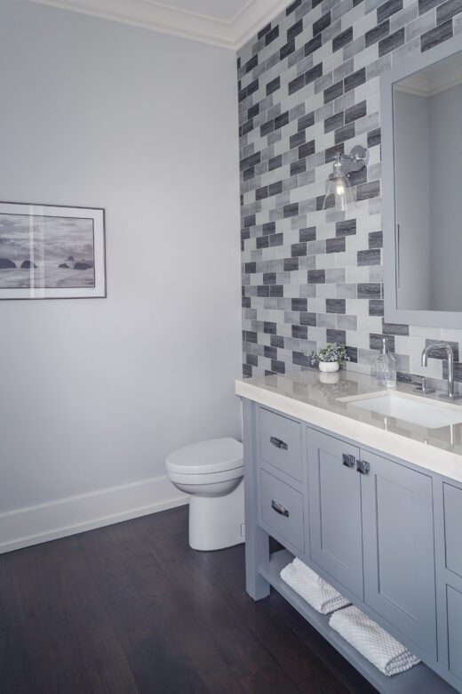 gray white Glass tile bathroom accent wall in powder room gray painted vanity