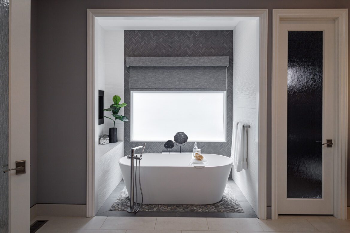 Primary bathroom remodel, white freestanding tub, chevron tile wall, fireplace