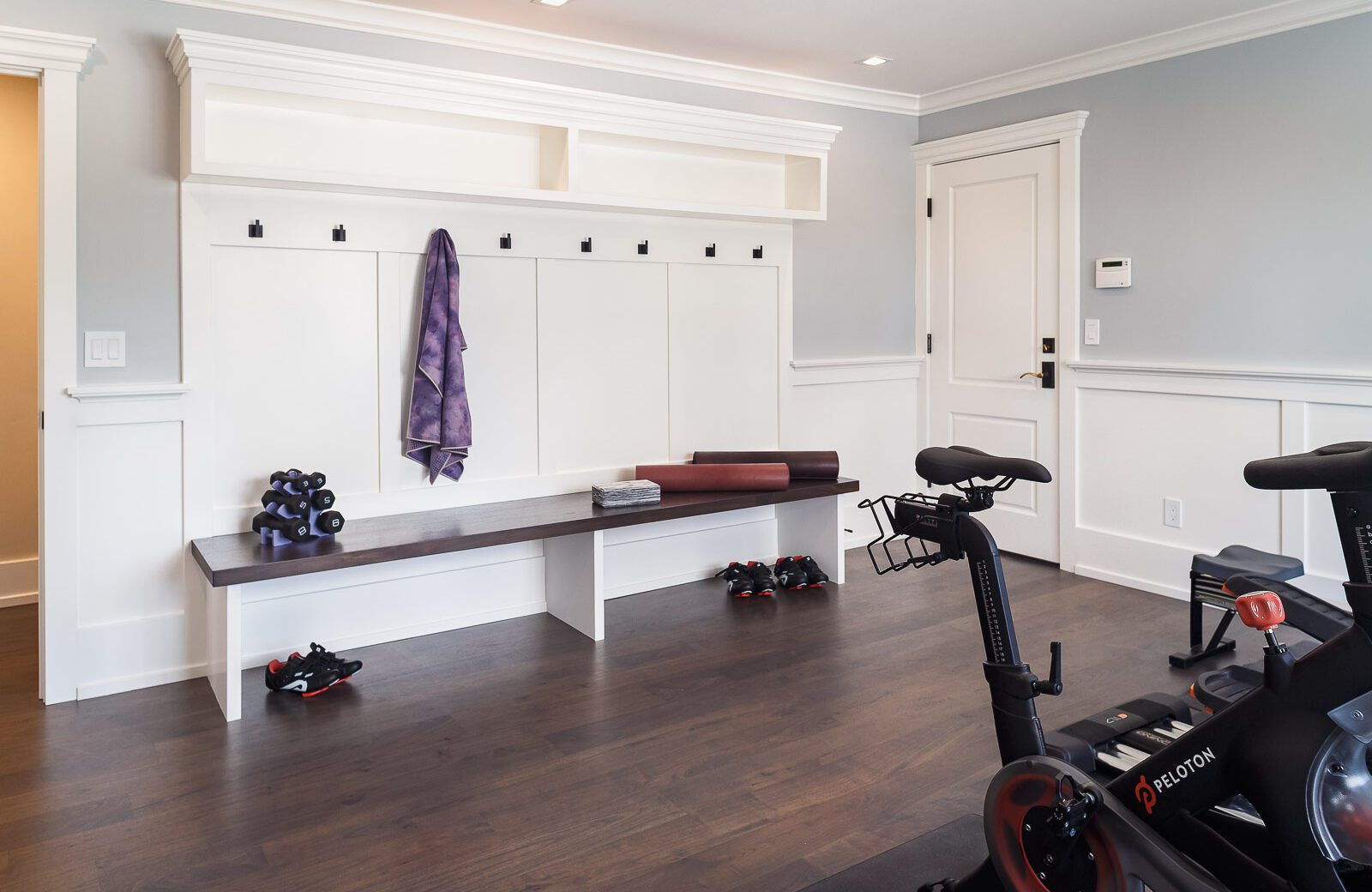 landing zone remodel for home gym with custom white cabinets, hardwood floors