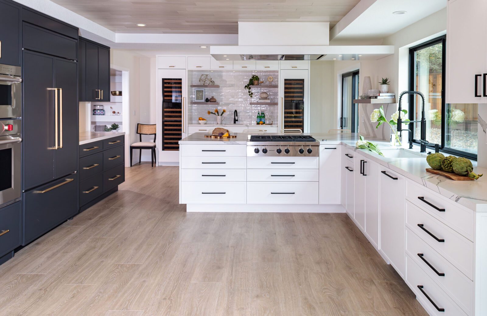 Lovely two toned kitchen with black cabinets and white cabinets, gold cabinetry hardware and matte black cabinetry hardware.