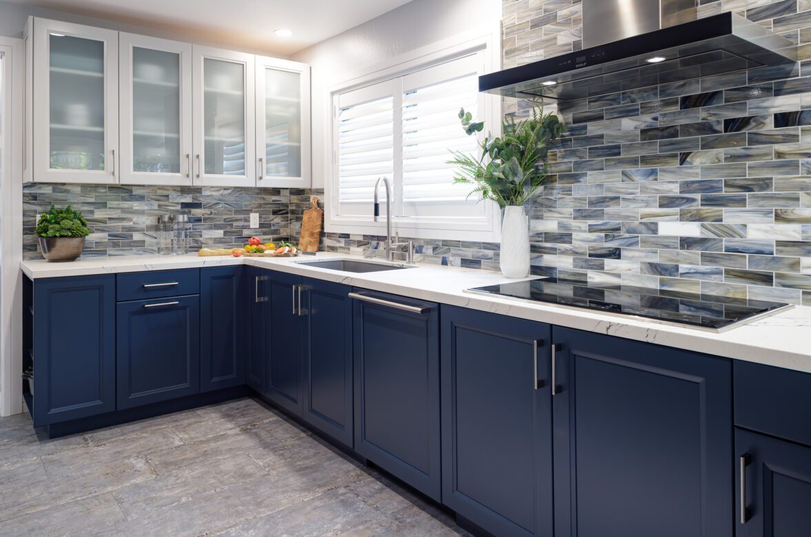kitchen remodel with dark blue cabinets and glass mosaic tile backsplash, gray tile floors