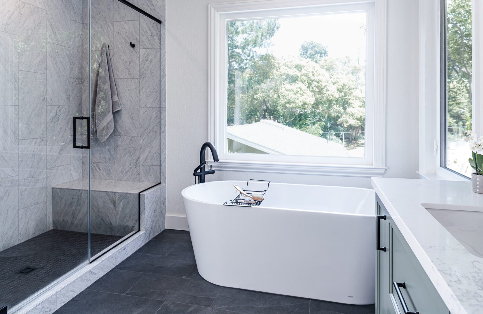 Primary bathroom remodel, freestanding white tub, marble shower tile, slate floor