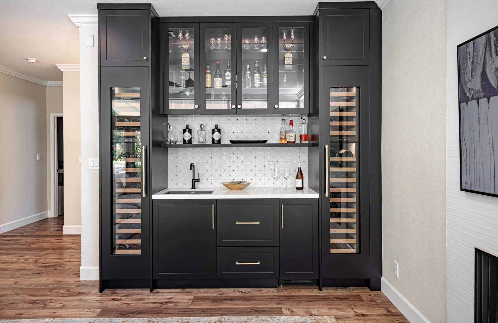 Large bar with black cabinetry, white tile and subzero wine fridges
