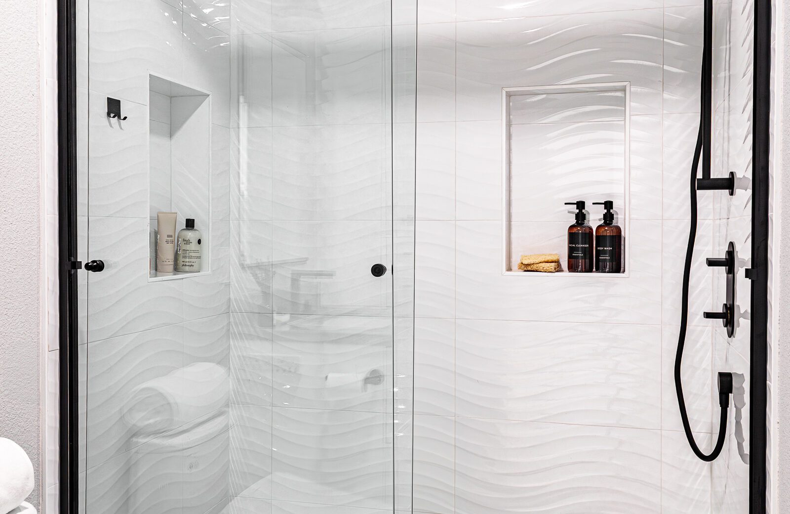 large white tile shower with glass door niche black accents in bathroom remodel danville ca