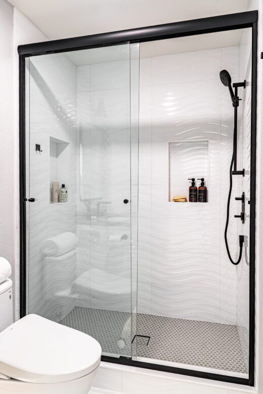 large white tile shower with glass door niche black accents in bathroom remodel danville ca