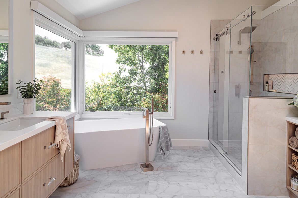 Danville, CA primary bathroom remodel with soaking tub, satin brass tub filler and large format white and graytile floors.