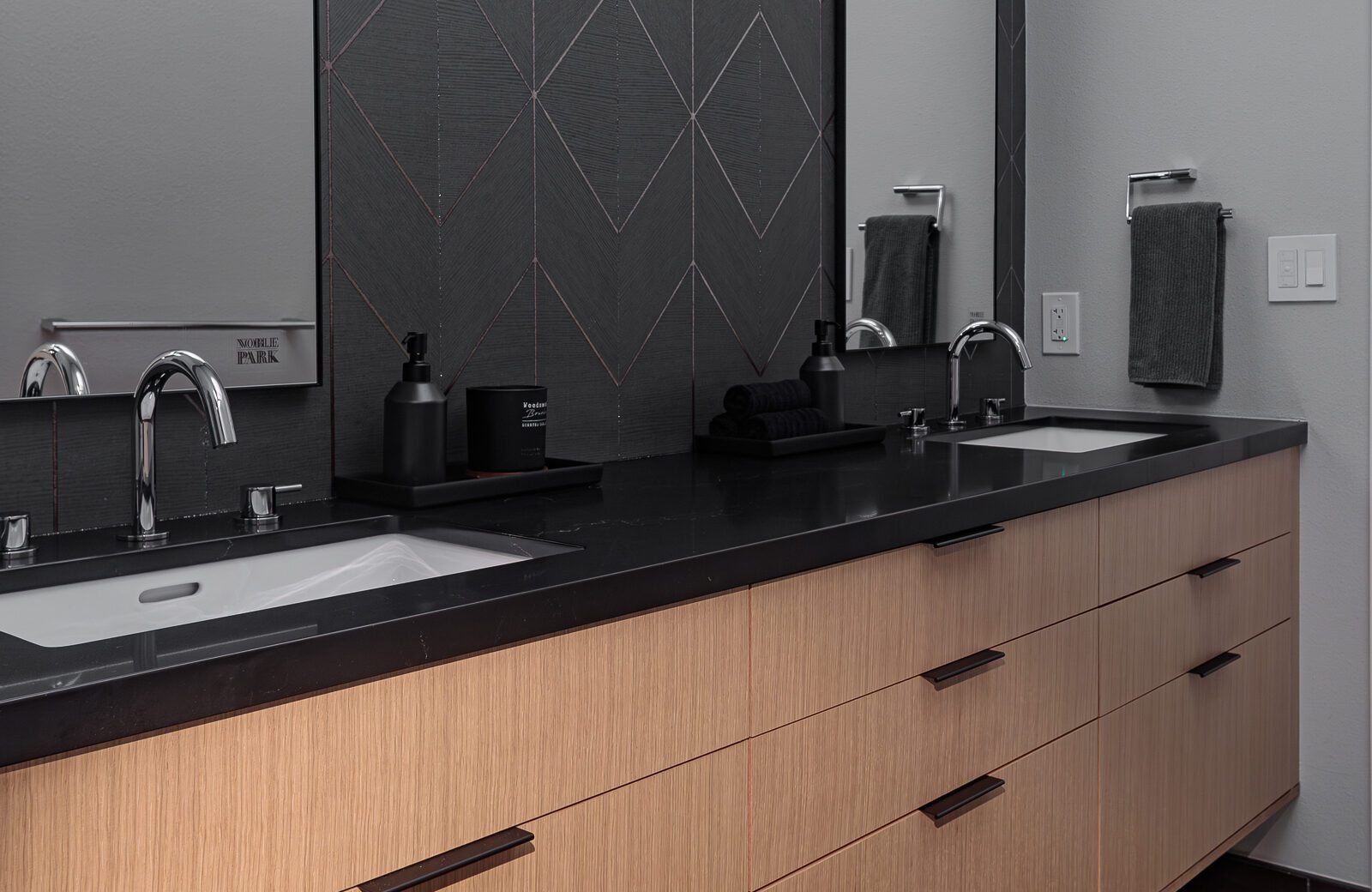 double sinks on a floating vanity wood vanity with black counters shows how much storage is possible