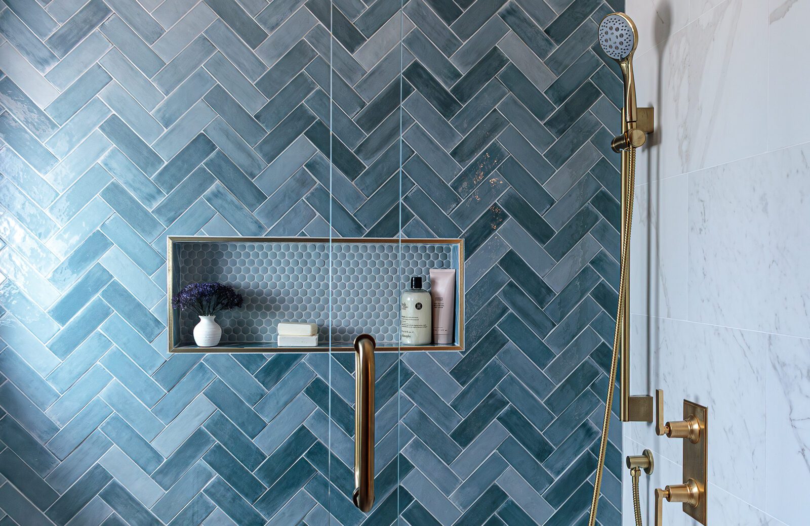 hall bath remodel with blue herringbone tile shower wall, satin brass plumbing fixtures