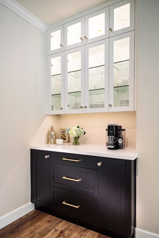 custom dry bar with glass door cabinets, quartz countertops, two toned cabinets