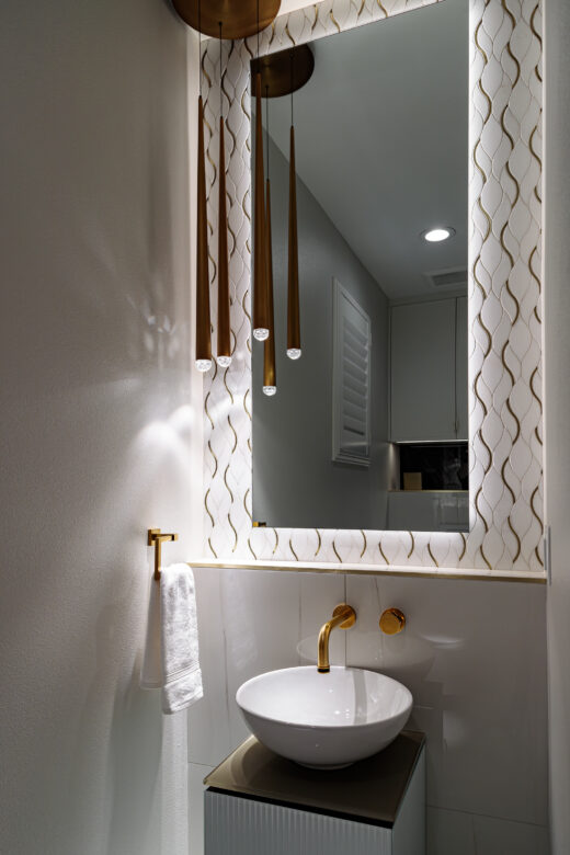 powder room with hanging pendant lights, tile backsplash and vessel sink