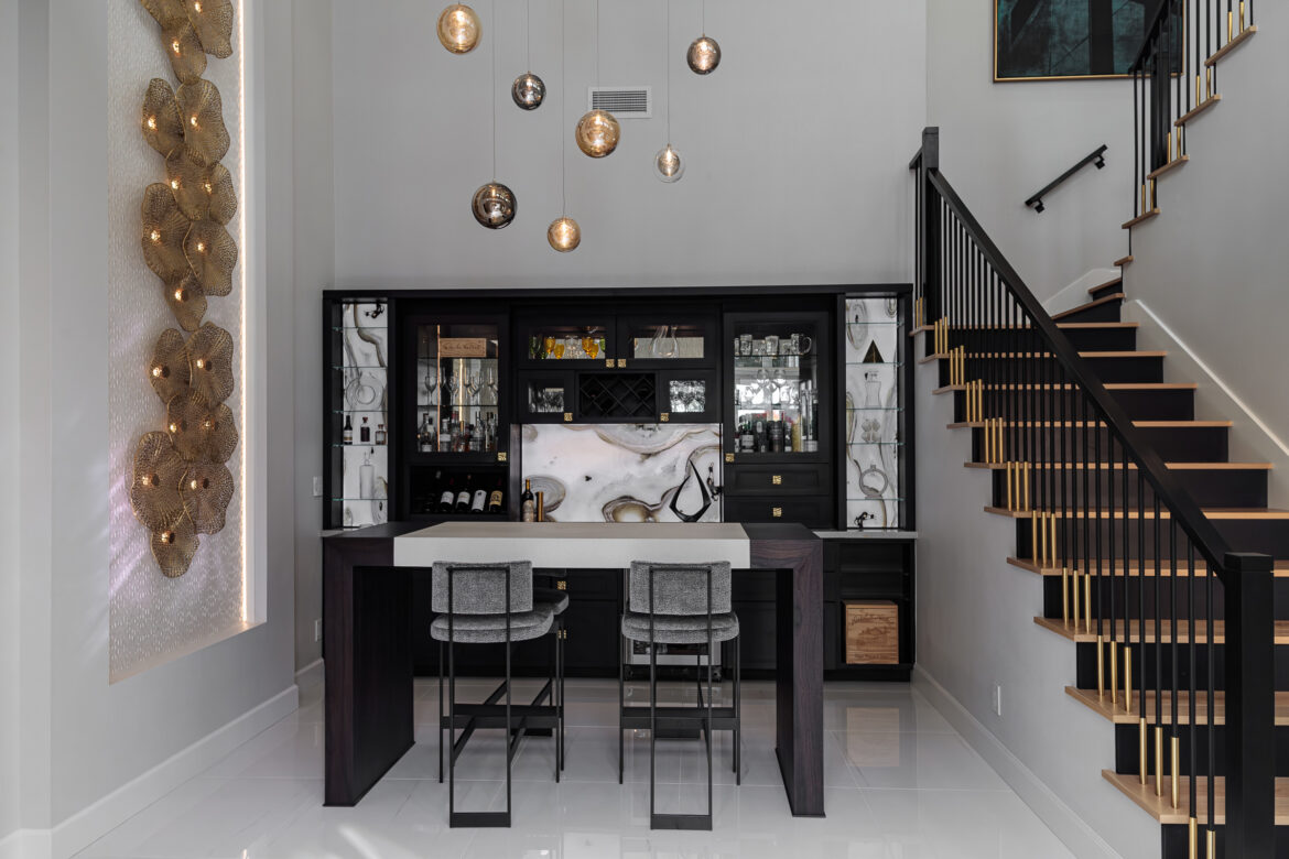 custom bar with llighted cabinets, hanging pendant lights