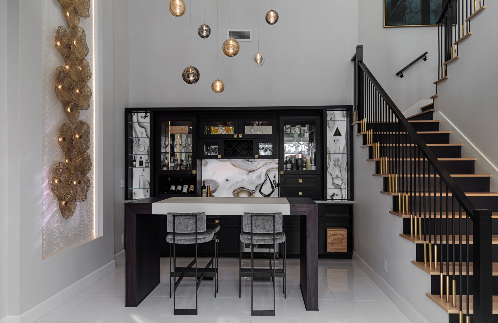 custom bar with llighted cabinets, hanging pendant lights