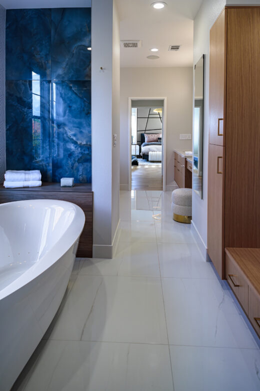 primary bathroom with large jetted soaking tub, blue wall tile, bench seating