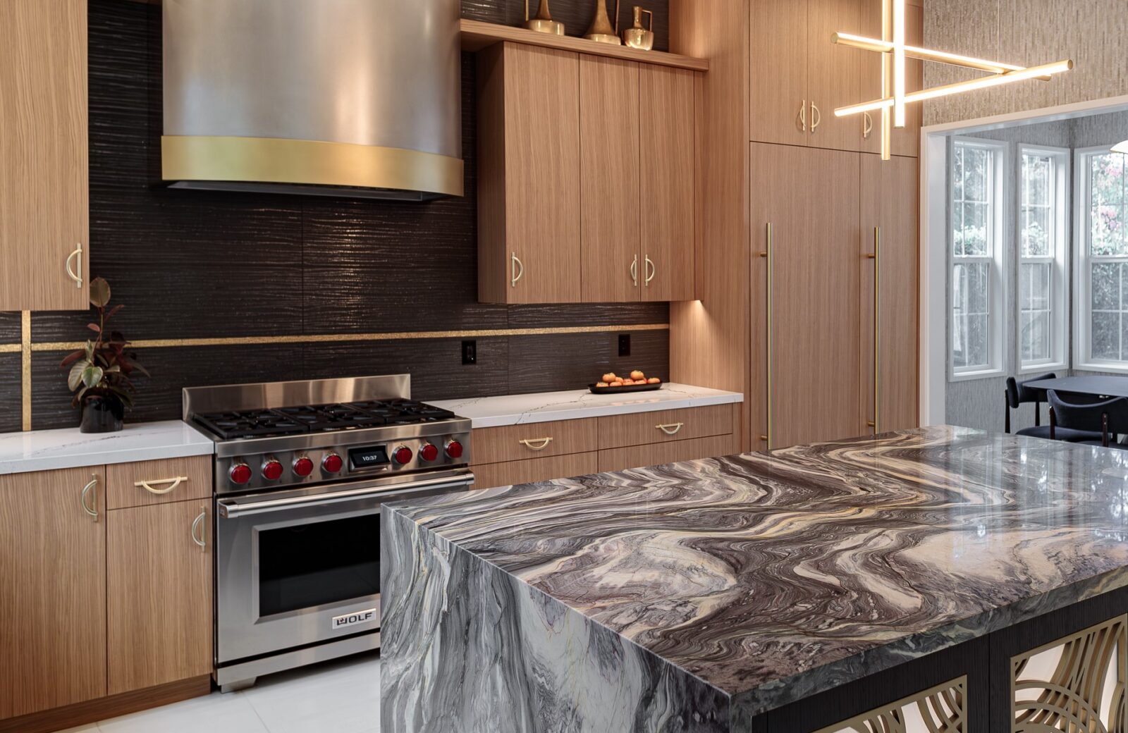 black tile backsplash around a custom metal hood, with accent tile