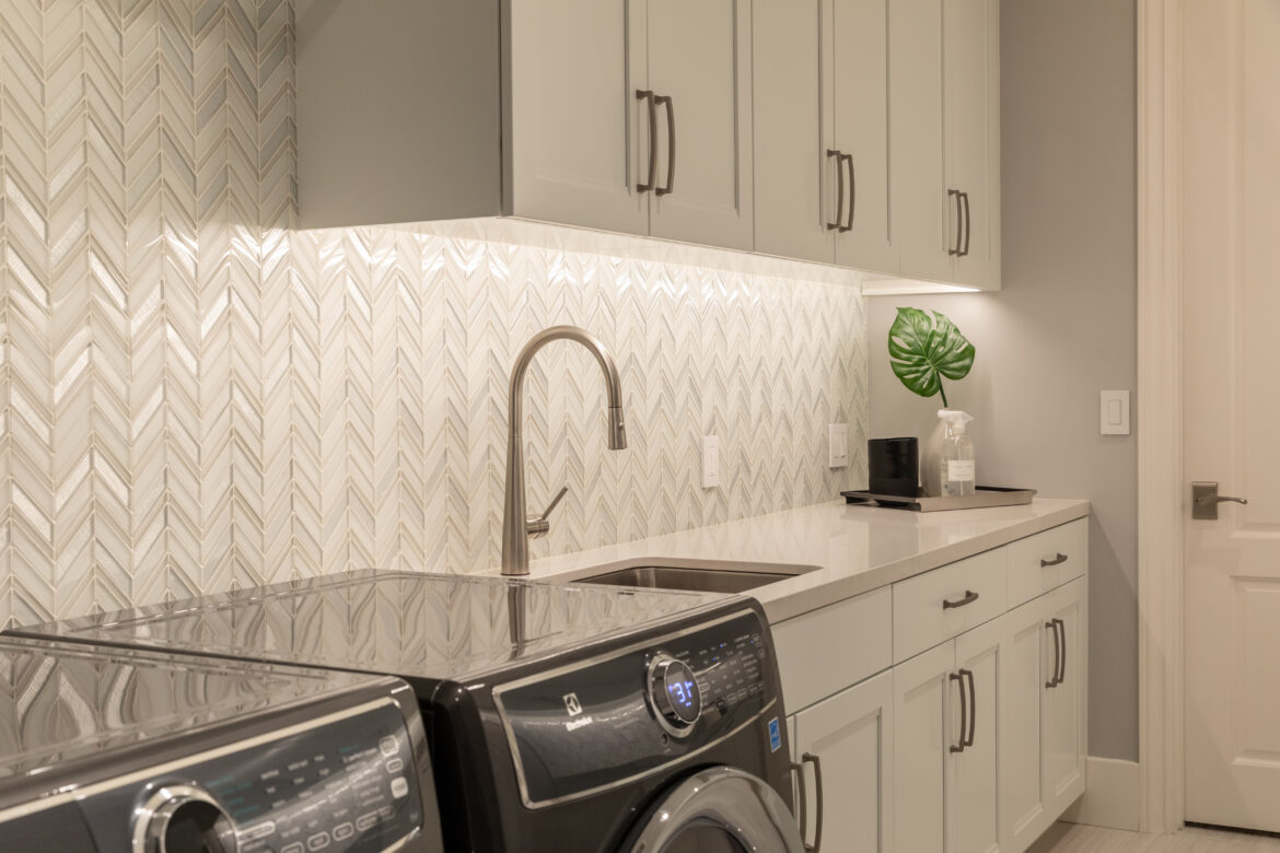large laundry room, custom cabinetry with sink, chevron tile backsplash